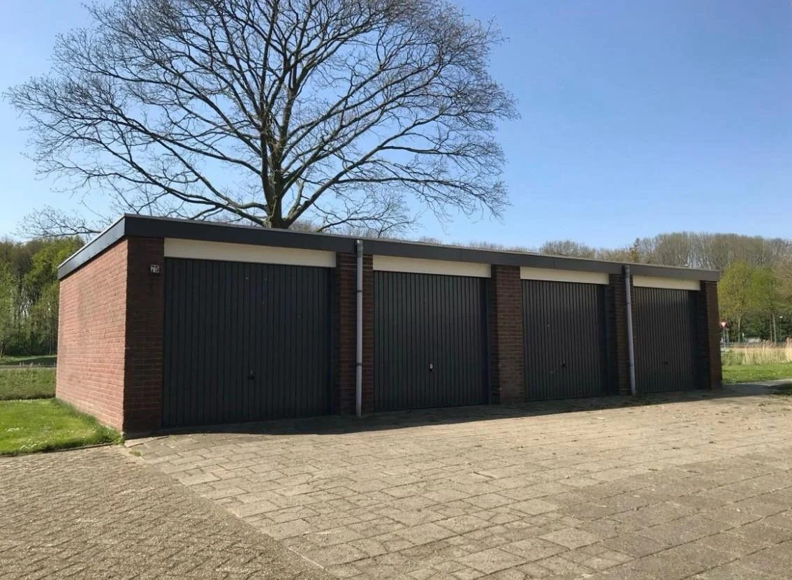 Rij van vier garageboxen met donkere kanteldeuren aan de Kastanjestraat in Goes
